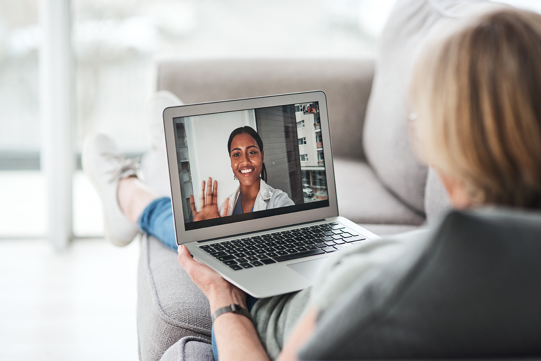 Shot of a senior woman using a laptop to make a video call with her doctor on the sofa a home.